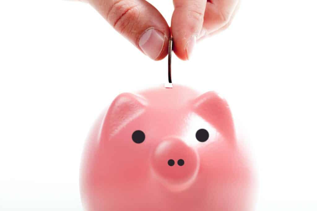 Savings - Piggy bank and hand with coin